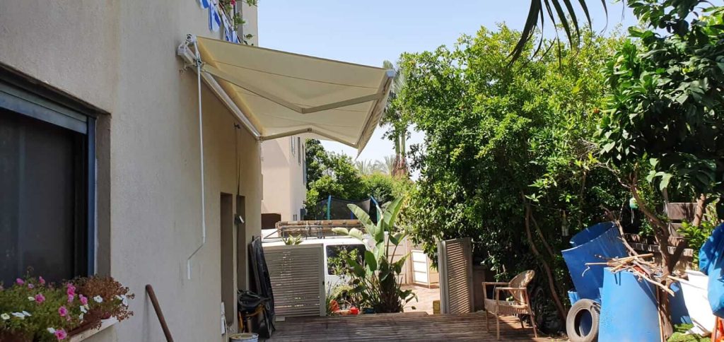 סוכך זרועות פתוח למרפסת ביתית מעניק הצללה יעילה ונוחות שימוש